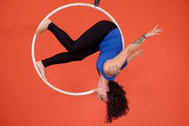 Aluna praticando acrobacia aérea em lira